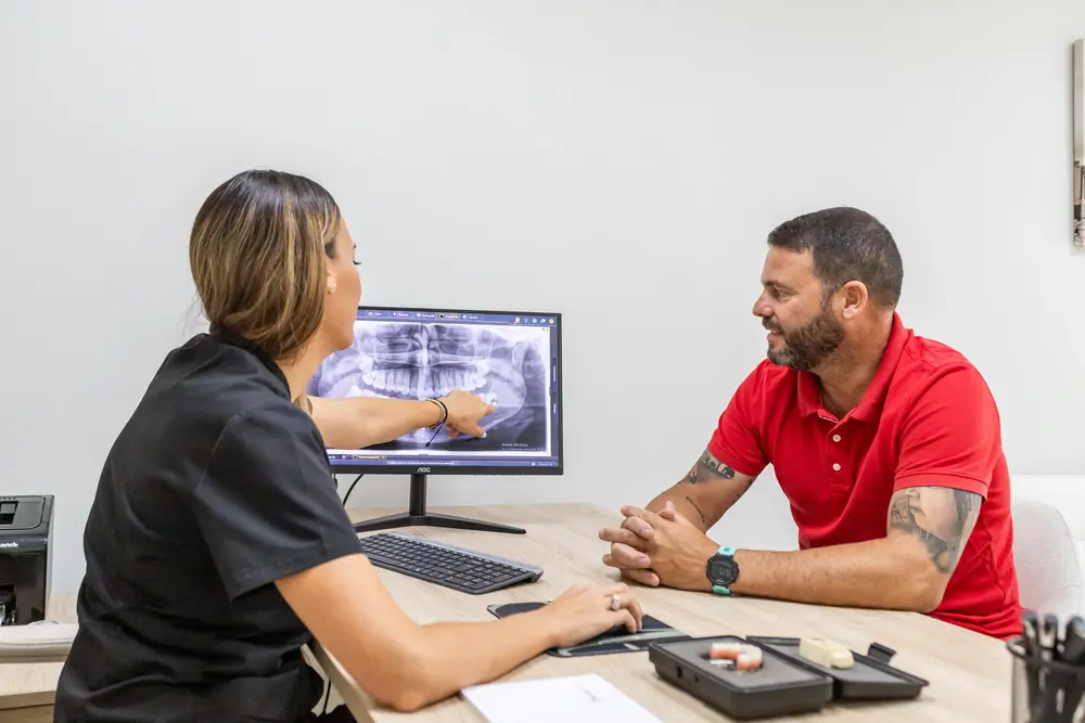 profesional de la clinica dental Adrichdental hablando con un paciente